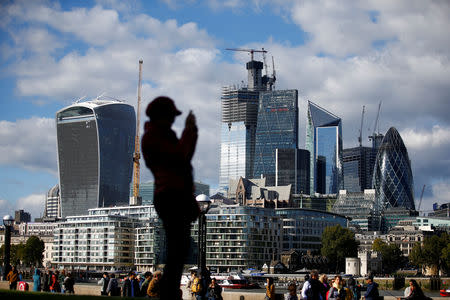 FILE PHOTO: A person takes a photograph with the financial district in the background, in London, Britain, September 23, 2018. REUTERS/Henry Nicholls