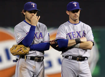 Ian Kinsler (left) and Michael Young, now veterans of two World Series defeats, stand on the field during the Rangers' 6-2 loss in Game 7