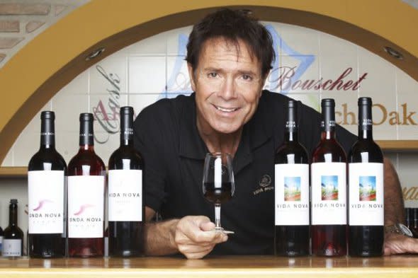 Cliff Richard with bottles of wine.
