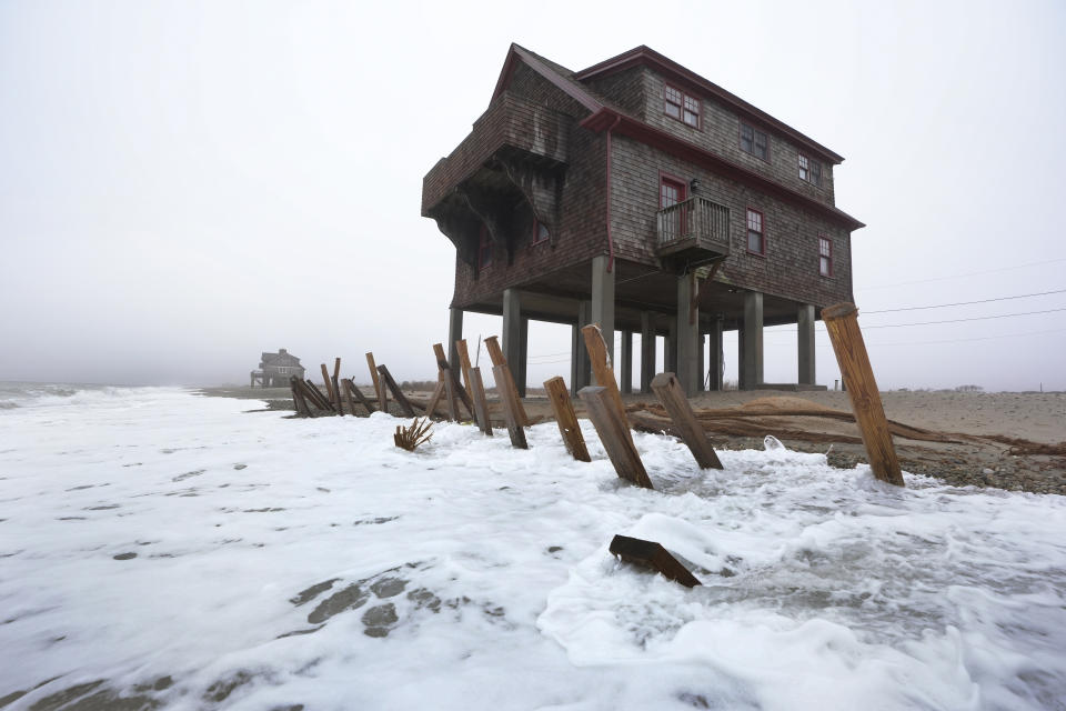 Houses resting on pylons are elevated above waves on the beach, Thursday, Jan. 25, 2024, in South Kingstown, R.I. Experts say erosion and receding shorelines are becoming more common due to ocean rise and climate change. (AP Photo/Steven Senne)