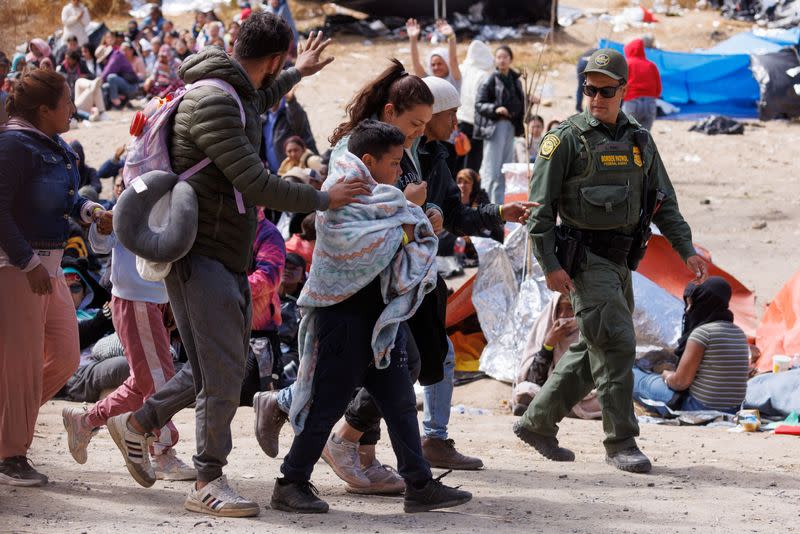 Migrants gather along the U.S. Mexico border near San Diego before the lifting of Tile 42