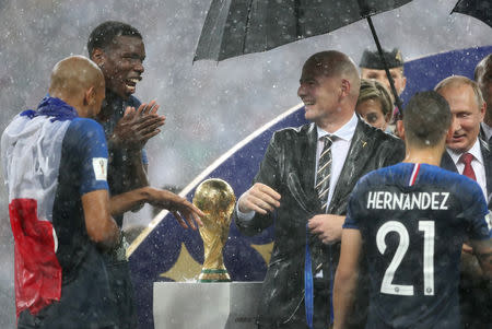 Soccer Football - World Cup - Final - France v Croatia - Luzhniki Stadium, Moscow, Russia - July 15, 2018 FIFA president Gianni Infantino with France's Paul Pogba and Steven Nzonzi next to the trophy as President of Russia Vladimir Putin awards France's Lucas Hernandez his winners medal REUTERS/Carl Recine