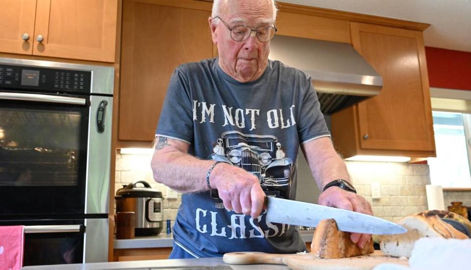 Melvin “Gabe” Gabelhaus, 98, slices fresh sourdough bread at his home in Modesto, Calif., Tuesday, August 22, 2023. Gabelhaus bakes several times a week and gives most of the baked goods to friends and neighbors. Andy Alfaro/aalfaro@modbee.com