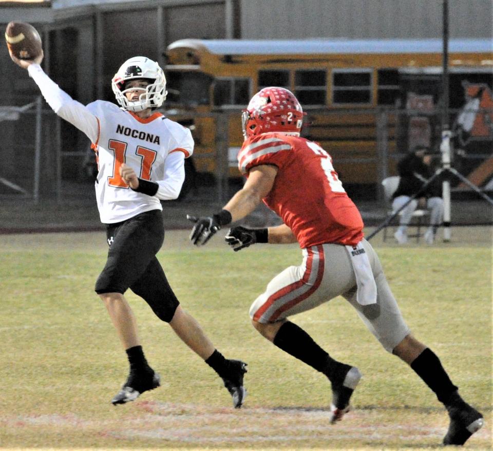 Nocona's Brady Mccasland throws the ball-avoiding a Holliday defender on Thursday, October 21, 2021 at Holliday.