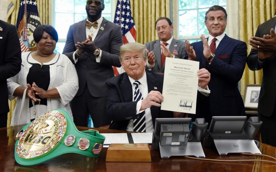 US President Donald Trump holds a signed Executive Grant of Clemency for boxer 'Jack Johnson' in the Oval Office - Pool/Getty Images North America 