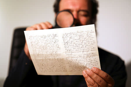 Meron Eren of Kedem Auction House holds a letter handwritten by composer Richard Wagner in 1869, before it is sold at an auction in Jerusalem, April 24, 2018. REUTERS/Ammar Awad