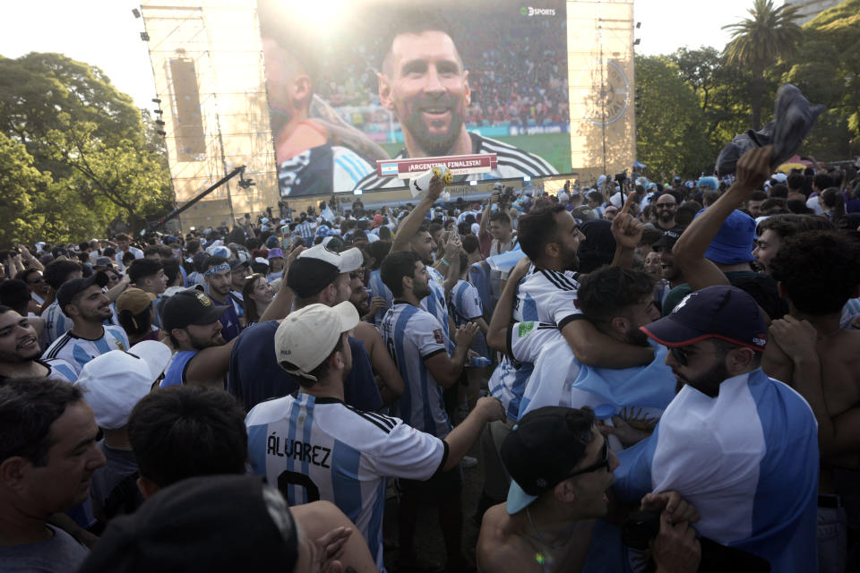 Argentina soccer fans celebrate their team's victory over Croatia at the end of the team's World Cup semifinal match in Qatar after watching it on a screen, where Lionel Messi's live image is shown, in the Palermo neighborhood of Buenos Aires, Argentina, Tuesday, Dec. 13, 2022. (AP Photo/Rodrigo Abd)