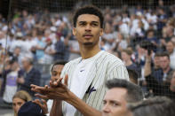 Victor Wembanyama, a projected first-round NBA draft pick, stands on the warning track after throwing the ceremonial first pitch before a baseball game between the New York Yankees and the Seattle Mariners, Tuesday, June 20, 2023, in New York. (AP Photo/John Minchillo)