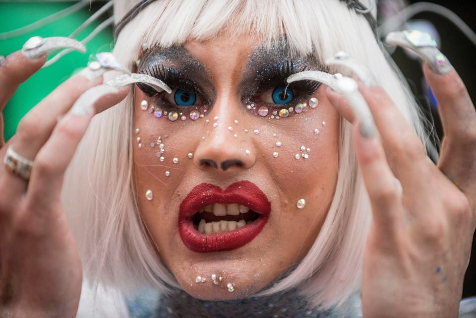 A gay and lesbian rights activist gestures during the annual Gay Pride parade, protected by riot police in Kyiv, Ukraine, June 17, 2018. Several thousand supporters of gay pride held a march in the Ukrainian capital that lasted about 20 minutes despite opponents' attempts to block them.