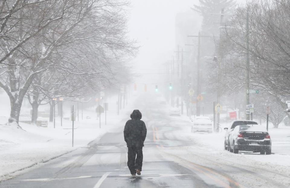 A man walks along the slush and snow on Broom Street in Wilmington as a winter storm passes through Saturday morning, Jan. 29, 2022.
