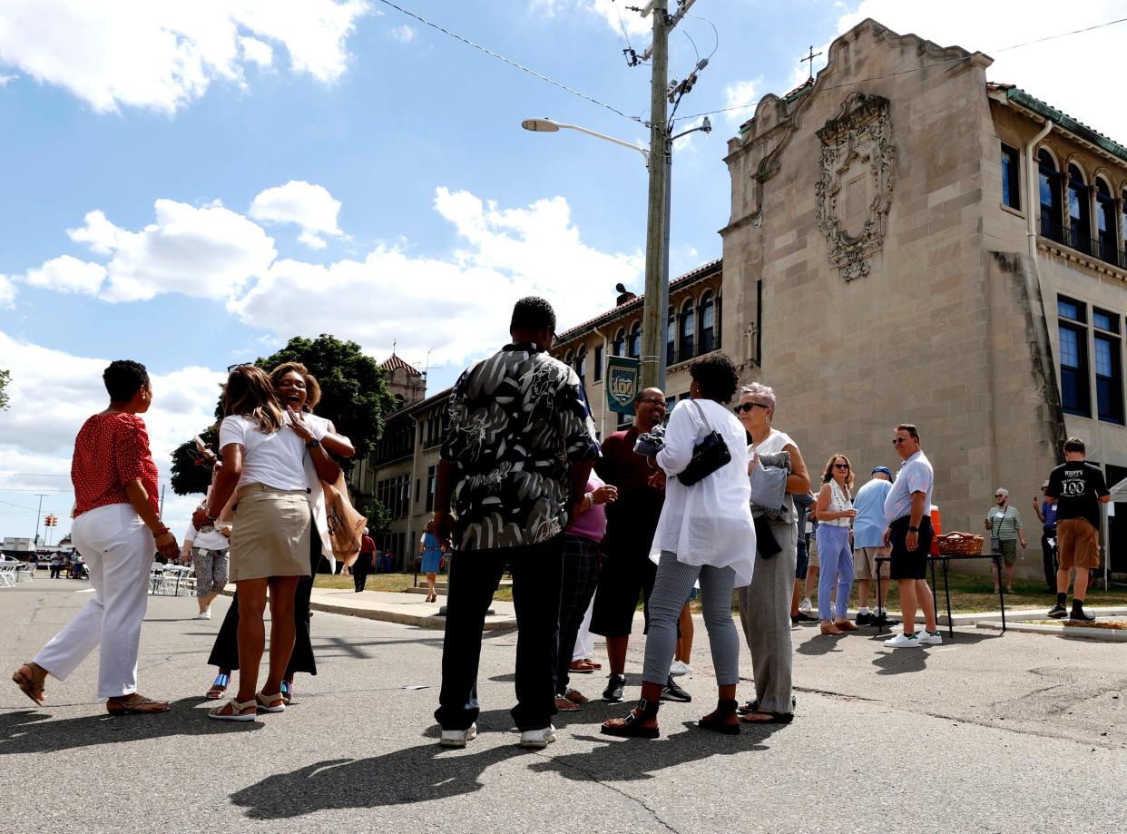 Former students from the Gesu School in Detroit gather and talk outside of their old school during the 100-year celebration at Gesu Catholic Church and School in Detroit on Saturday, July 30, 2022.