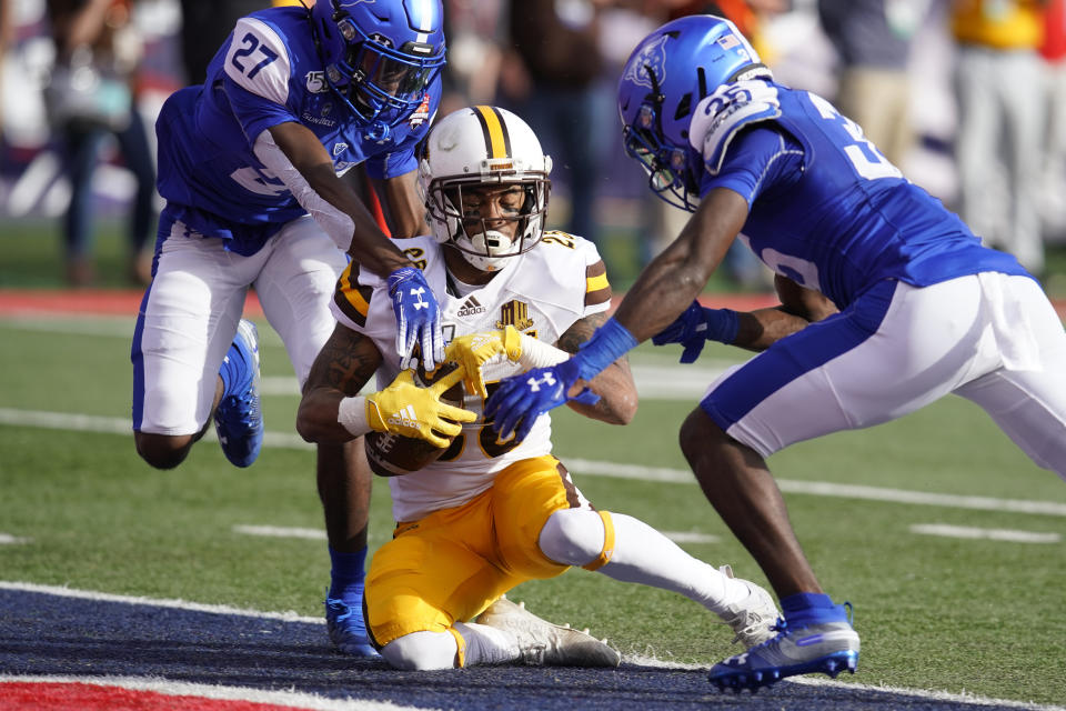 Wyoming wide receiver Austin Conway (25) makes the catch for a touchdown in between Georgia State cornerback Jaylon Jones (27) and Keon Carter in the first half of the Arizona Bowl NCAA college football game, Tuesday, Dec. 31, 2019, in Tucson, Ariz. (AP Photo/Rick Scuteri)