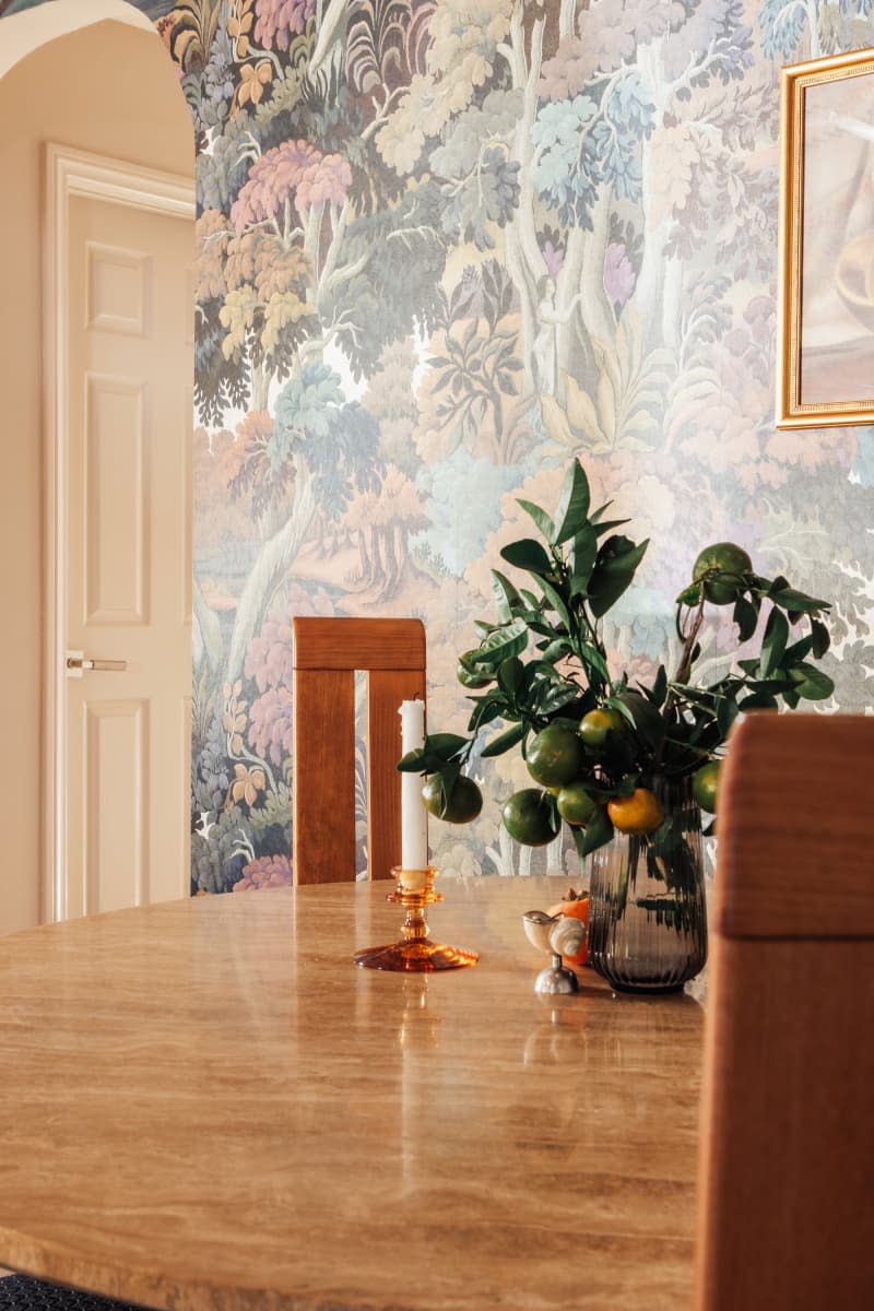 dining room with trees wallpaper and wood round dining table