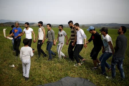 Migrants and refugees dance at a field at a makeshift camp at the Greek-Macedonian border near the village of Idomeni, Greece, April 1, 2016. REUTERS/Marko Djurica