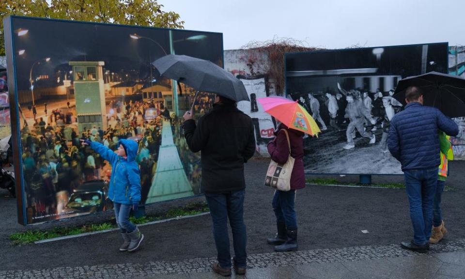 Visitors look at photographs from 1989 at Bernholmer Bridge