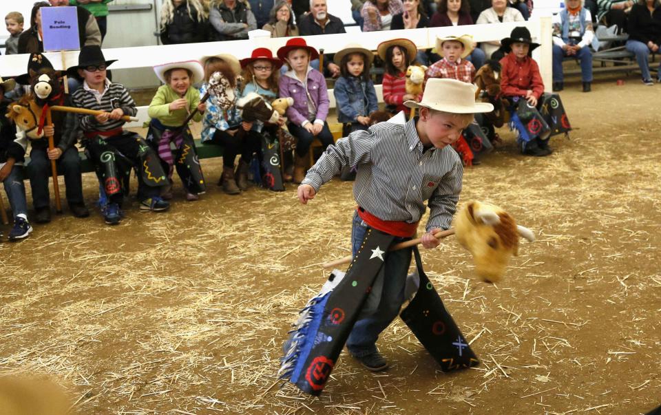 A boy competes in the stick horse rodeo bull riding competition at the 108th National Western Stock Show in Denver January 11, 2014. The show, which features more than 15,000 head of livestock, opened on Saturday and runs through January 26. REUTERS/Rick Wilking (UNITED STATES - Tags: ANIMALS SOCIETY TPX IMAGES OF THE DAY)