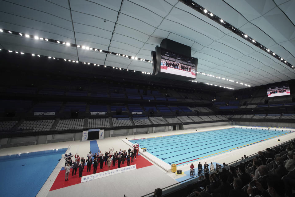 Tokyo Gov. Yuriko Koike and other guests pose for photos during a grand opening ceremony of Tokyo Aquatics Center Saturday, Oct. 24, 2020, in Tokyo. The Tokyo 2020 organizing committee held the grand opening ceremony Saturday at the aquatics center, planned to host Olympic artistic swimming, diving and swimming and Paralympics swimming events in 2021. (AP Photo/Eugene Hoshiko)