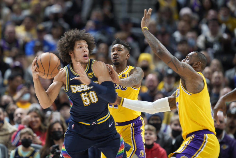 Denver Nuggets forward Aaron Gordon, front left, looks to pass the ball as Los Angeles Lakers forward LeBron James, front right, and guard Malik Monk defend in the first half of an NBA basketball game Saturday Jan. 15, 2022, in Denver. (AP Photo/David Zalubowski)