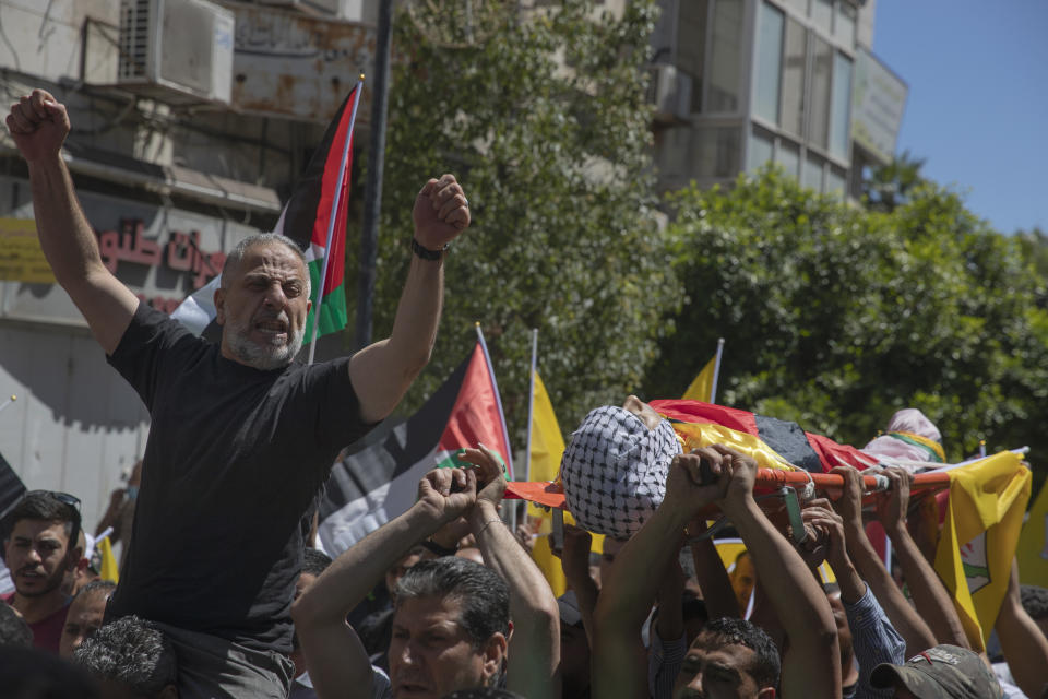 Palestinian mourners chant slogans while carrying the body of Islam Bernat, 16, during his funeral in the West Bank city of Ramallah, Wednesday, May 19, 2021. Multiple protesters were killed and more than 140 wounded in clashes with Israeli troops in Ramallah, Bethlehem, Hebron and other cities on Tuesday, according to the Palestinian Health Ministry. The Israeli army said at least a few soldiers were wounded in Ramallah by gunshots to the leg. (AP Photo/Nasser Nasser)