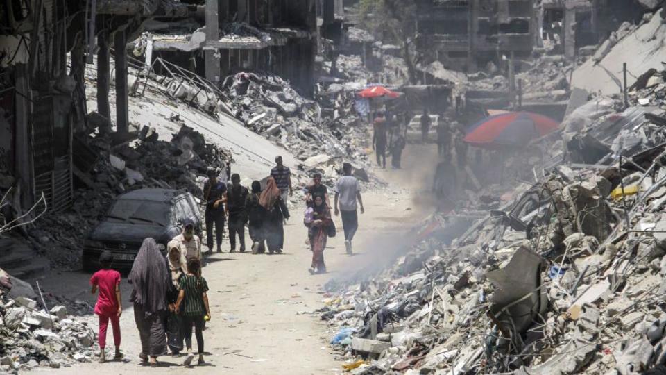 People walk in destroyed city of Khan Younis