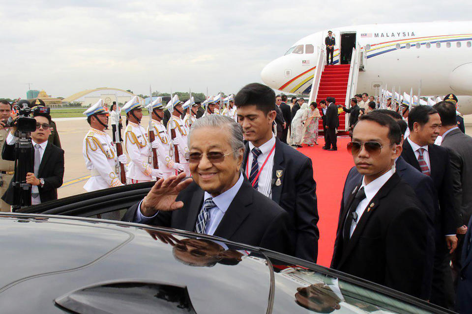 In this photo provided by Agence Kampuchea Presse (AKP), Malaysian Prime Minister Mahathir Mohamad, center, waves to Cambodian government officers upon his arrival at Phnom Penh International Airport, Monday, Sept. 2, 2019, in Phnom Penh, Cambodia. Mahathir has arrived in Cambodia for a three-day official visit to strengthen the two countries' bilateral relationship. (Khem Sovannara, Agence Kampuchea Presse via AP)