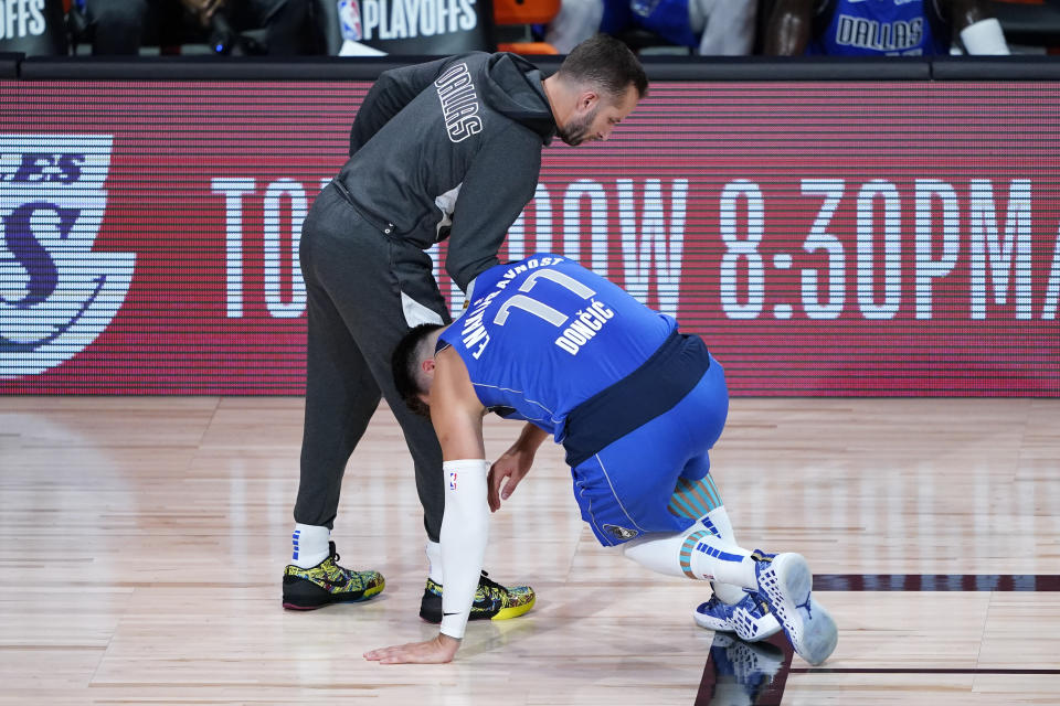 Dallas Mavericks' Luka Doncic (77) stumbles as he leaves the court after being injured during the second half of an NBA basketball first round playoff game against the Los Angeles Clippers Friday, Aug. 21, 2020, in Lake Buena Vista, Fla. (AP Photo/Ashley Landis, Pool)