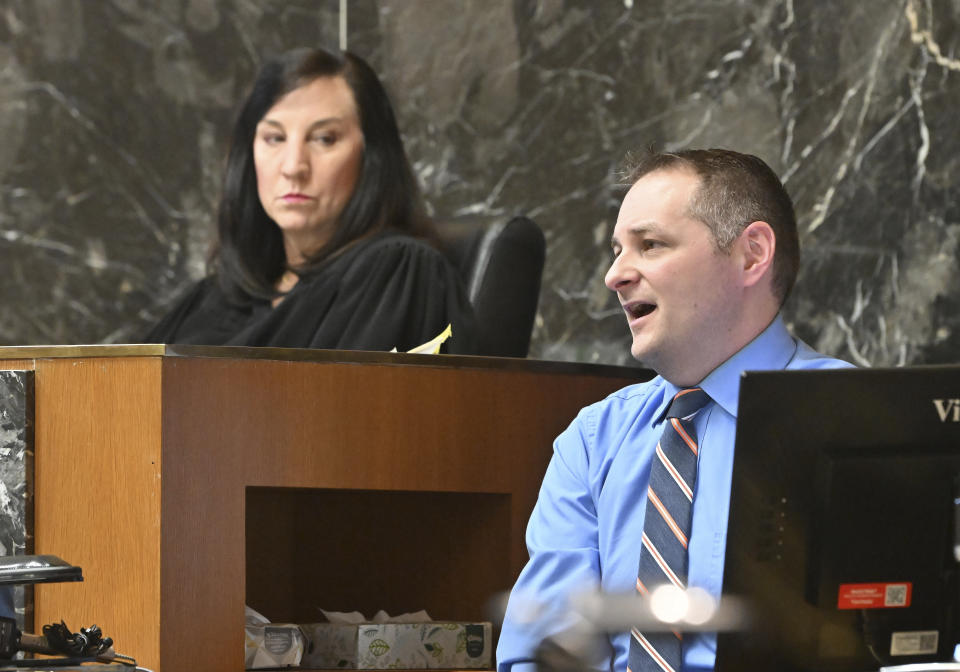 Oxford High School counselor Shawn Hopkins, with Oakland County Judge Cheryl Matthews looking on, on the stand during the James Crumbley trial in an Oakland County Courtroom on Monday, March 11, 2024, in Pontiac, Mich. Crumbley is on trial for involuntary manslaughter in his 15-year-old son's killing of four students at Oxford High School. (Daniel Mears/Detroit News via AP, Pool)