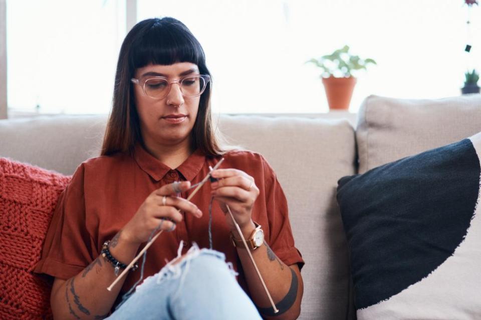 Young woman knitting at home