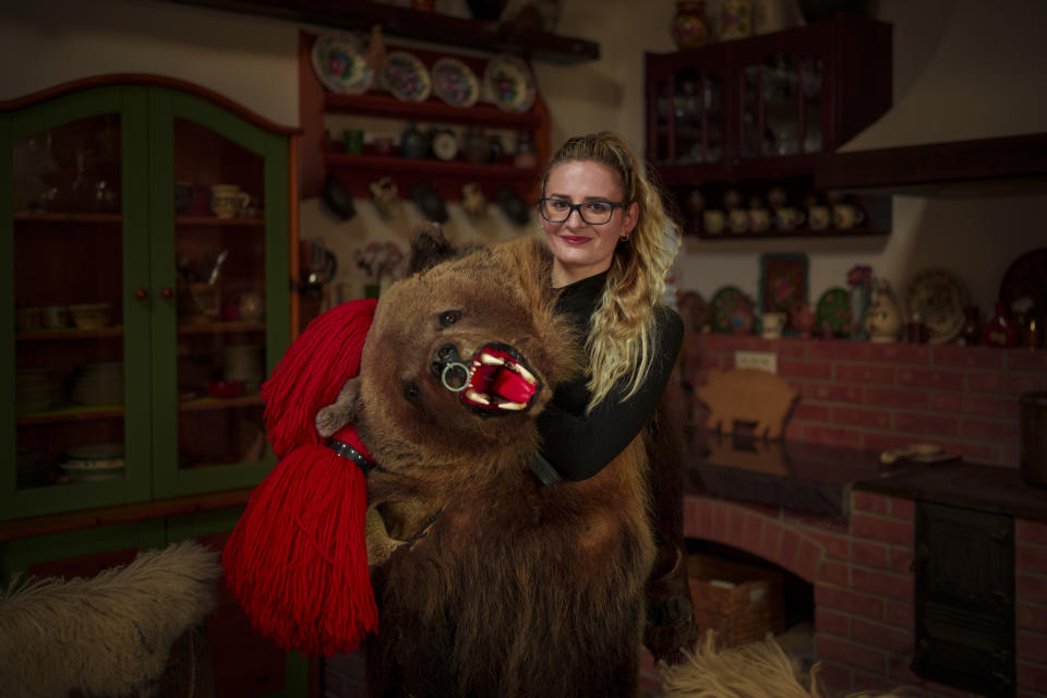 Stefania, 22 years-old, a member of the Sipoteni bear pack, poses for a portrait in Comanesti, northern Romania, Wednesday, Dec. 27, 2023. Stefania first wore the bear fur costume when she was 17 years-old and loves to dance. (AP Photo/Andreea Alexandru)