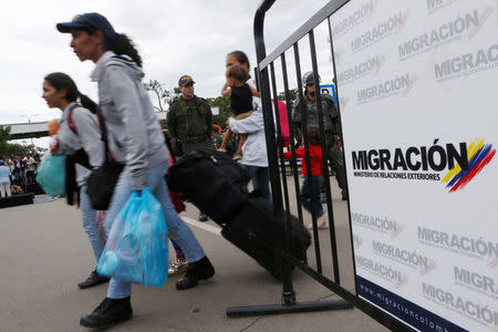 Venezuelan migrants carry their luggage to cross from Venezuela to Colombia via the Simon Bolivar international bridge in Cucuta, Colombia August 8, 2018. REUTERS/Luisa Gonzalez