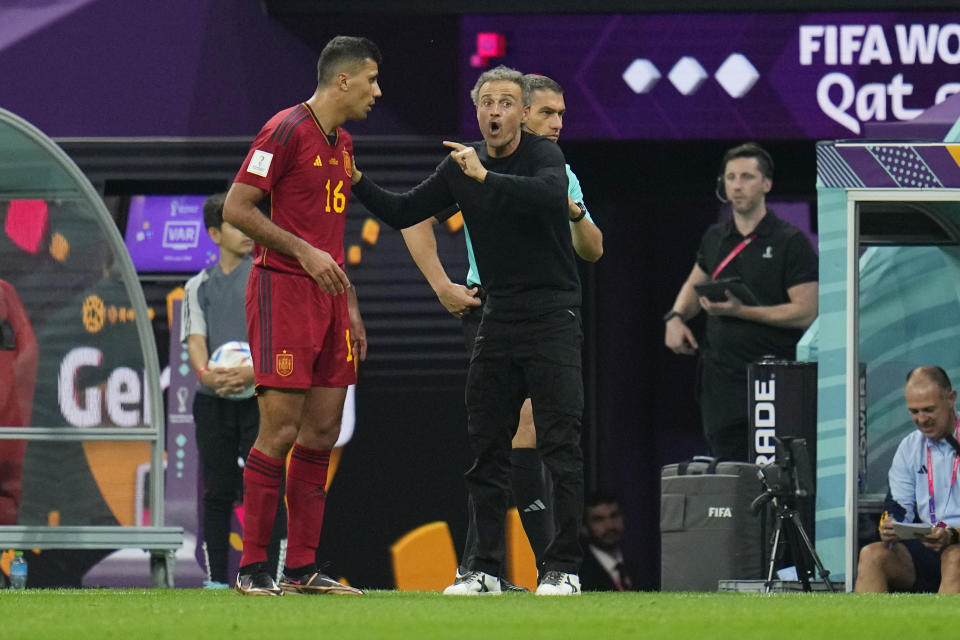 Spain's head coach Luis Enrique, right, talks with his player Rodri during the World Cup group E soccer match between Spain and Germany, at the Al Bayt Stadium in Al Khor , Qatar, Sunday, Nov. 27, 2022. (AP Photo/Julio Cortez)