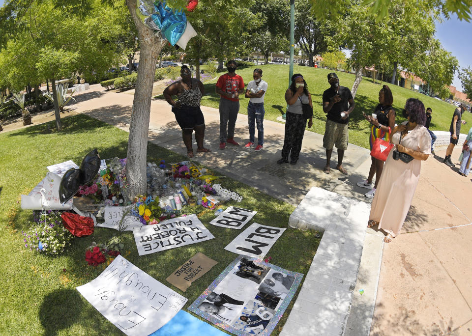 FILE - In this Monday, June 15, 2020, file photo, people stand by a memorial as they gather near the site where Robert Fuller was found hanged in Palmdale, Calif. A police investigation confirmed suicide was the cause of death of Fuller, a Black man found hanging from a tree in a Southern California city park last month, authorities said Thursday, July 9, 2020. (AP Photo/Mark J. Terrill, File)