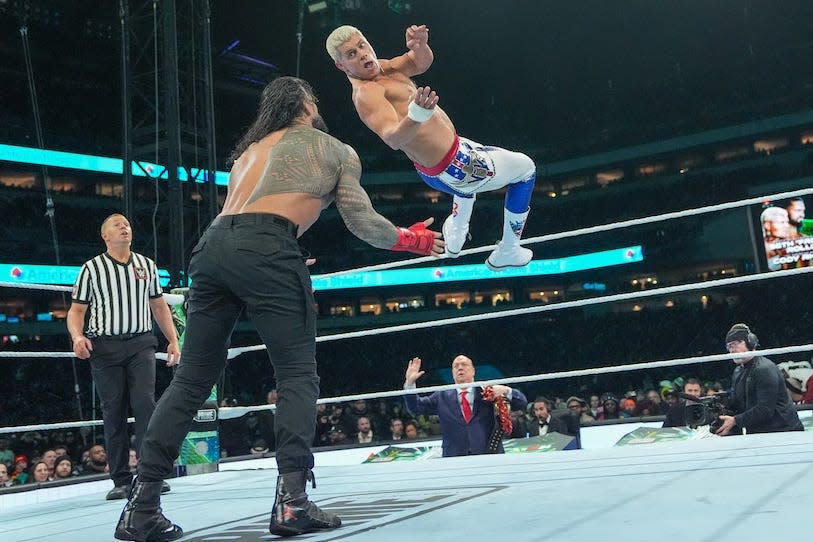 Cody Rhodes, jumping backwards mid-air off the top rope, turns to face a standing Roman Reigns during Night One of WrestleMania 40 at Lincoln Financial Field on April 6, 2024 in Philadelphia, Pennsylvania.