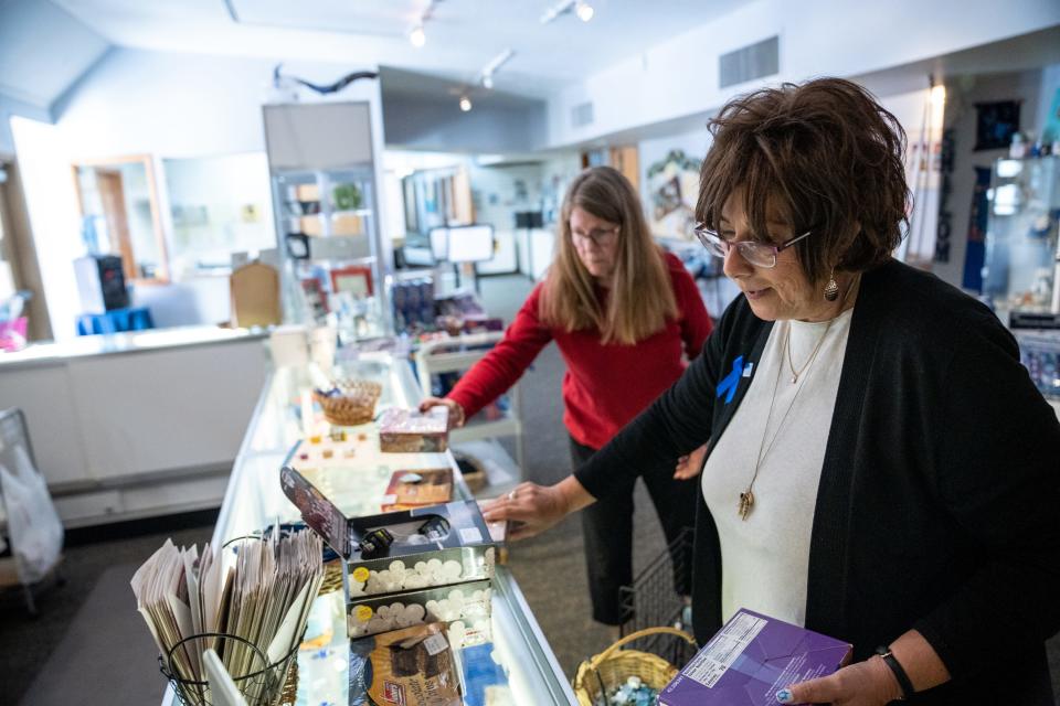 Temple Chai’s Judaica Shop shopper Barbara Newmeyer, left, and shop manager Joan Near, right, stock merchandise inside the shop in Phoenix, on Dec. 6, 2023.