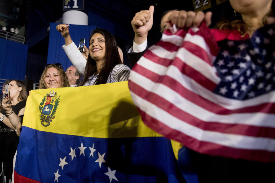 Members of the audience wave Venezuelan and American flags as President Donald Trump speaks to a Venezuelan American community at Florida Ocean Bank Convocation Center at Florida International University in Miami, Fla., Monday, Feb. 18, 2019, to speak out against President Nicolas Maduro's government and its socialist policies. (AP Photo/Andrew Harnik)