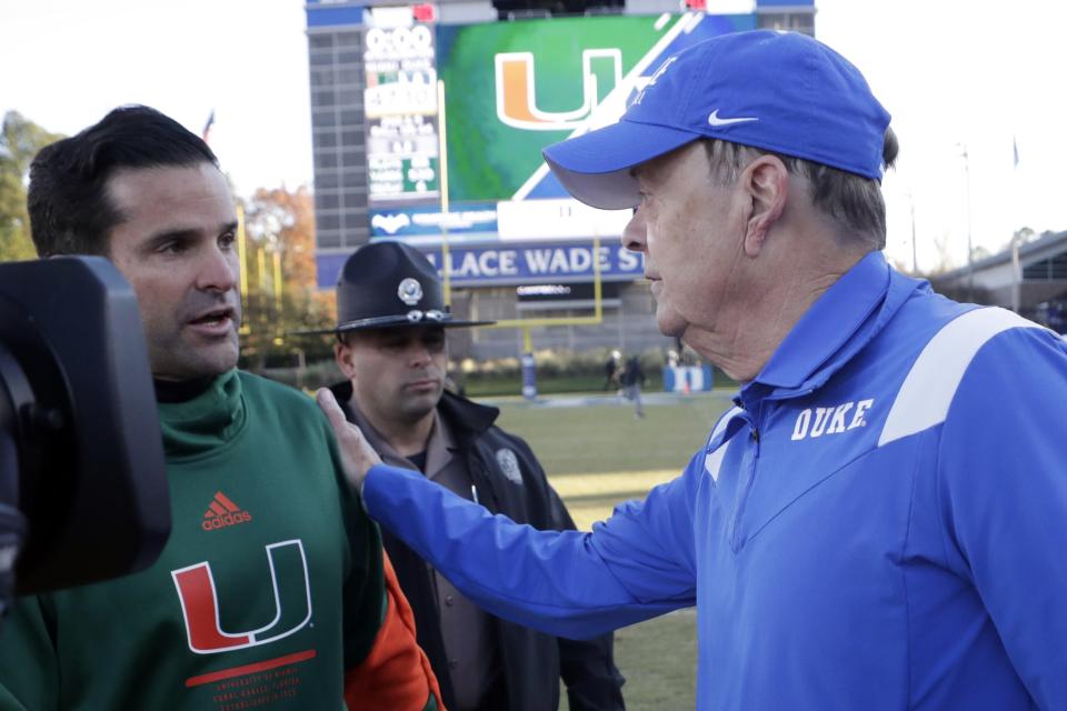 Miami head coach Manny Diaz (left) and Duke head coach David Cutcliffe meet at the end of Saturday's game in Durham, N.C. Cutcliffe was fired Sunday. Diaz awaits his fate. (AP Photo/Chris Seward)