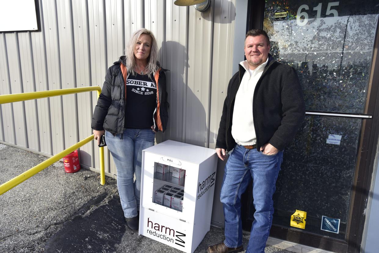 Blue Water Recovery and Outreach Center staff member Barbara Alexander and executive director Patrick Patterson pose beside the new news stand that provides free Narcan kits outside the facility located at 617 10th St., in Port Huron, on Thursday, Dec. 1, 2022. BWROC installed the stand in partnership with Harm Reduction Michigan - a healthy equity organization based in Traverse City that aims to reduce the harmful effects of substance use disorder on society.