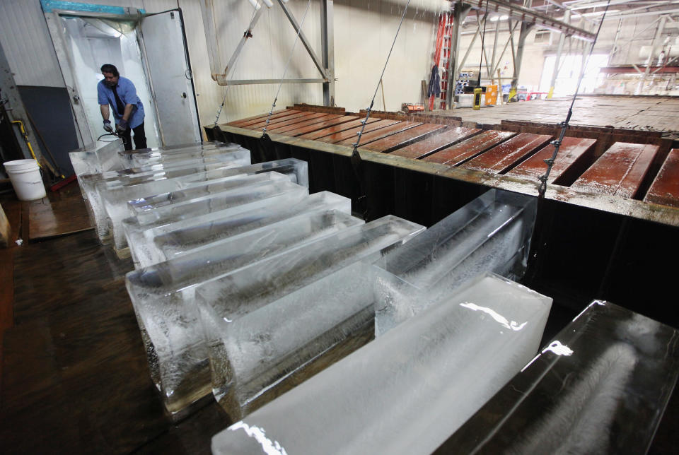 Ricky Perez unloads 300-pound blocks of ice from a brine tank to be sold at Arctic Glacier Premium Ice on July 17, 2012 in the Bronx borough of New York City. Perez said, "Right now we are selling these things like crazy." The blocks take three days to freeze in the tank and sell for $75. A heat advisory was issued in the city again today as high temperatures were expected in the 90?s though tomorrow. (Photo by Mario Tama/Getty Images)