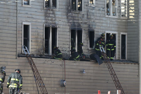 Firefighters battle a four-alarm blaze in a three-story apartment building in Oakland, California, U.S. March 27, 2017. REUTERS/Beck Diefenbach