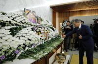 South Korean President Moon Jae-in places a flower at a memorial altar for the late former sex slave and activist Kim Bok-dong, Wednesday, Jan. 29, 2019, in Seoul, South Korea. Hundreds of South Koreans are mourning Kim's death in Seoul Wednesday demanding reparations from Tokyo over their wartime atrocities. (Bee Jae-man/Yonhap via AP)