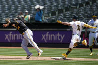 Oakland Athletics' Abraham Toro (31) reaches first base safely as Pittsburgh Pirates first baseman Rowdy Tellez, left, reaches for a throwing error by shortstop Oneil Cruz during the fifth inning of a baseball game in Oakland, Calif., Wednesday, May 1, 2024. Oakland Athletics outfielder Tyler Nevin (26) scored on the play. (AP Photo/Jeff Chiu)