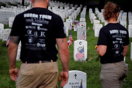 Mourners stand near the grave marker of U.S. Army Major James Michael Ahearn inside of Section 60 in Arlington National Cemetery on Memorial Day, May 30, 2016. REUTERS/Lucas Jackson