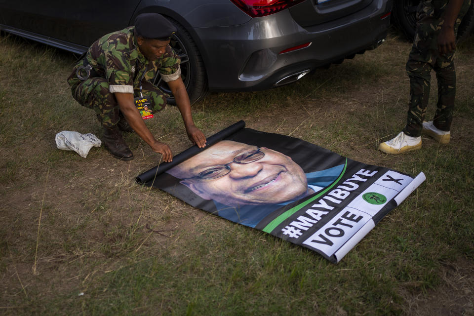 A military officer rolls up a poster of former South African President Jacob Zuma during an election meeting in Durban, South Africa, Saturday, May 25, 2024, in anticipation of the 2024 general elections scheduled for May 29. (AP Photo/Emilio Morenatti)