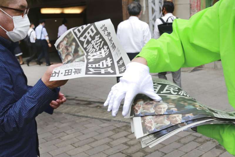 日本自由民主黨14日舉行總裁改選，菅義偉一如預期以高票勝出，日本讀賣新聞立刻在街頭發送快報。（美聯社）
