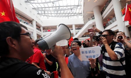 Pro-government and anti-government supporters chant against one another at a shopping mall in Hong Kong