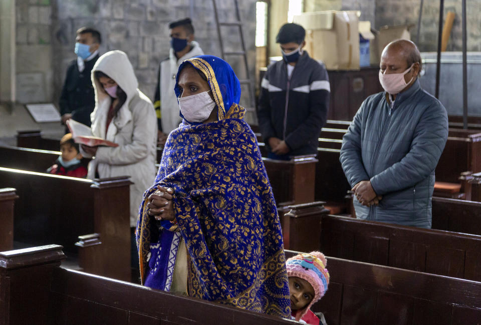 Indian Christians, who are registered members of St. John in the Wilderness church, maintain social distancing as they attend the Christmas mass in Dharmsala, India, Friday, Dec. 25, 2020. The church which was built in 1852, is currently closed to general visitors due to COVID-19 restrictions. (AP Photo/Ashwini Bhatia)