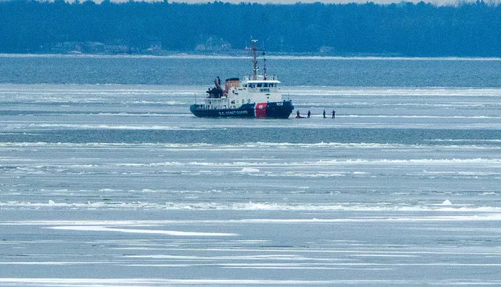 Personnel from the U.S. Coast Guard cutter Mobile Bay walk in the ice Wednesday, January 18, 2023 on Green Bay about 10 miles north of Green Bay, Wis. Ice has been slow to form this year with only 3 percent of the lakes covered as of Jan. 13. The near-record low is roughly 18 percent below average for this time of year.