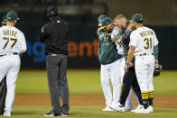 Oakland Athletics relief pitcher Joel Payamps (30) is helped off the field after being hit by a ball on a single hit by New York Yankees' Kyle Higashioka during the eighth inning of a baseball game in Oakland, Calif., Thursday, Aug. 25, 2022. (AP Photo/Godofredo A. Vásquez)