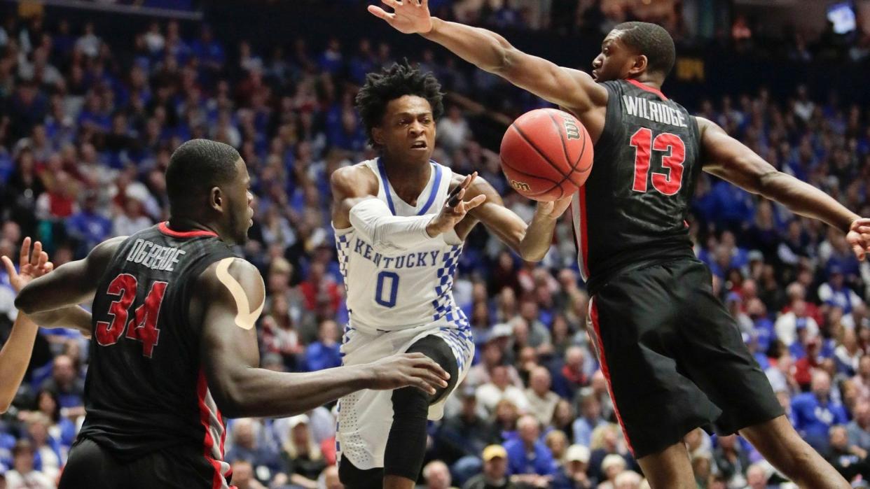 Mandatory Credit: Photo by AP/Shutterstock (8509690o)DeAaron Fox, Derek Ogbeide, ETorrion Wilridge Kentucky guard De'Aaron Fox (0) passes between Georgia defenders Derek Ogbeide (34) and E'Torrion Wilridge (13) during the second half of an NCAA college basketball game at the Southeastern Conference tournament, in Nashville, TennSEC Georgia Kentucky Basketball, Nashville, USA - 10 Mar 2017.