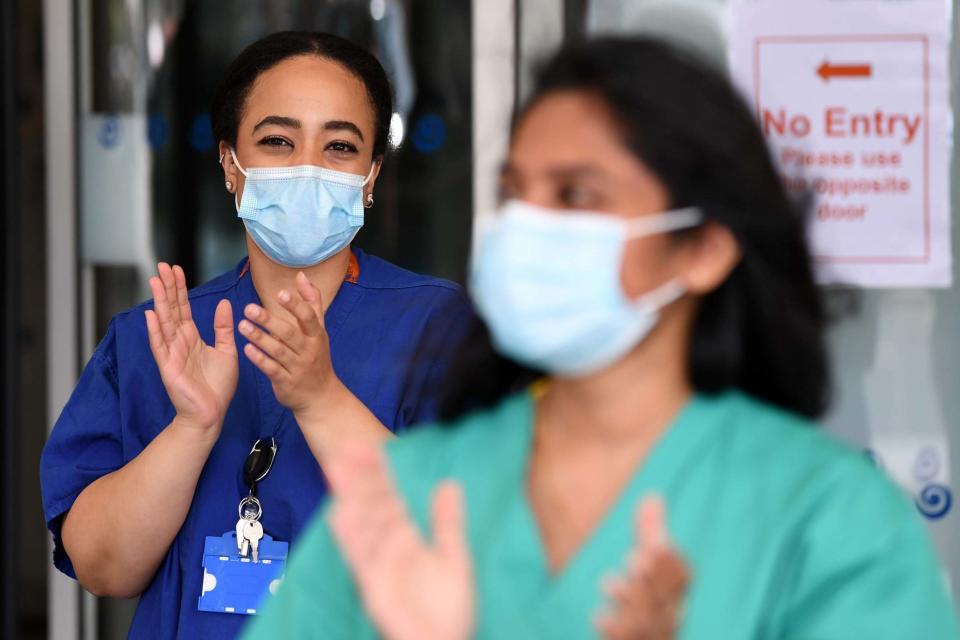 Members of staff at the Chelsea and Westminster Hospital participate in a national NHS (National Health Service) celebration clap outside the hospital (AFP via Getty Images)